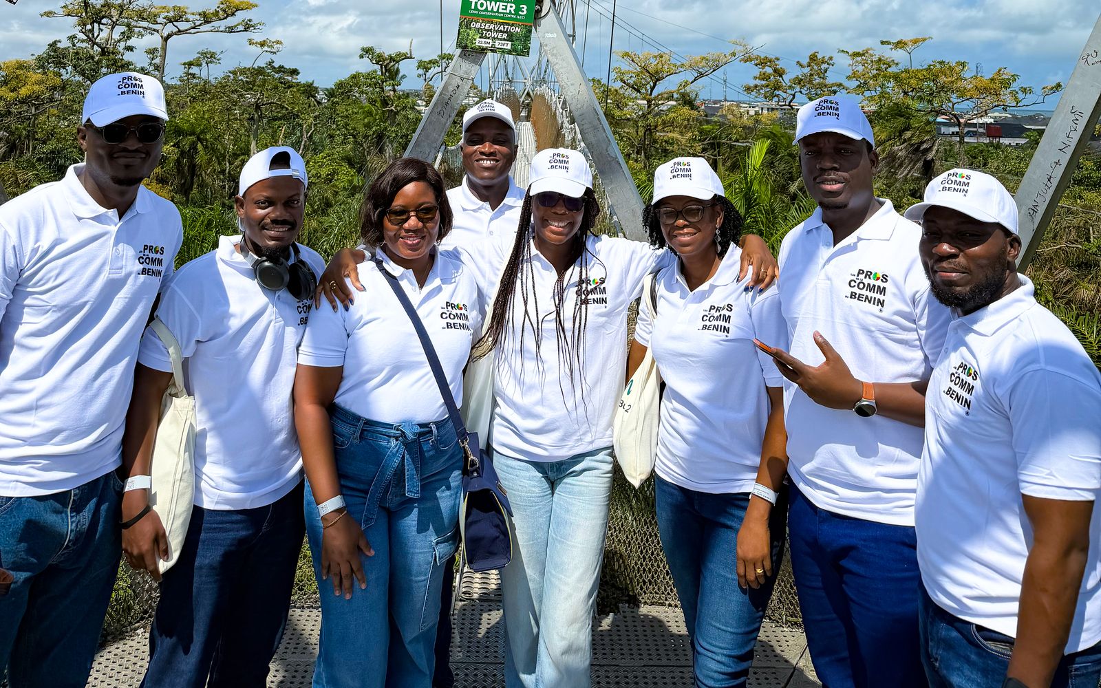 Membres de l’association en polos et casquettes Pros de la Comm’ sur la passerelle de canopée du Lekki Conservation Centre