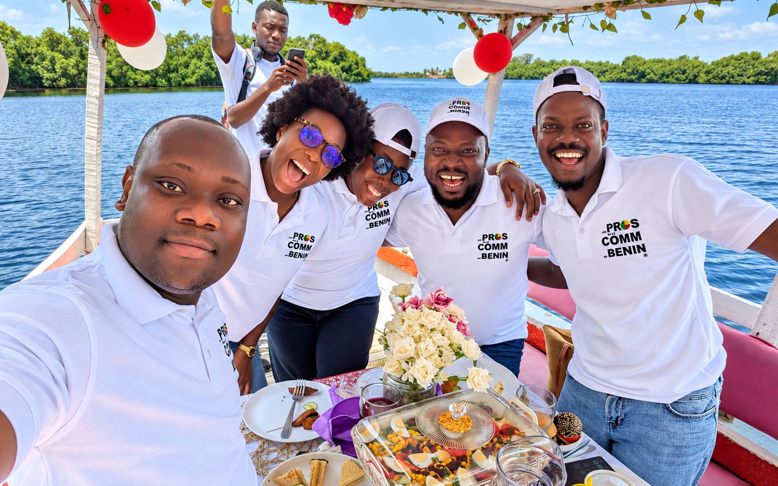 Selfie de six membres de l’association en polos Pros de la Comm’ autour d’une table sur un bateau, sur la lagune