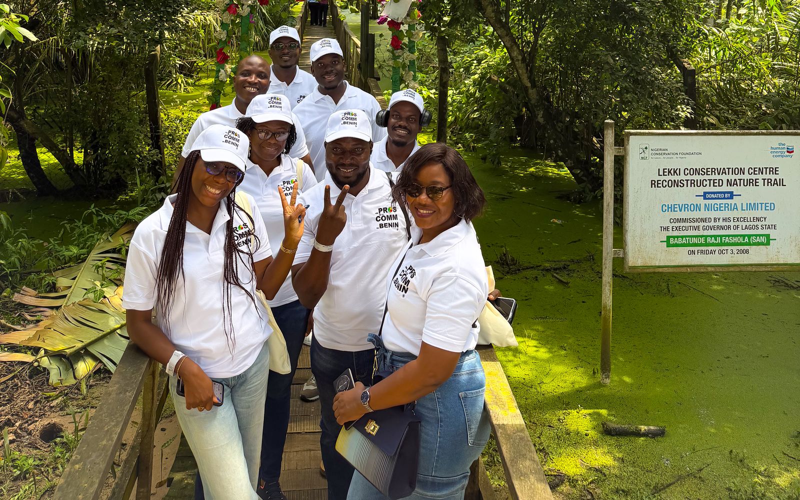 Membres de l’association souriants sur un sentier en bois au cœur de la forêt du Lekki Conservation Centre